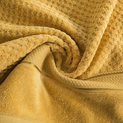 Ręcznik Jessi 50x90 musztardowy frotte 500g/m2 z fakturą wytłaczanej krateczki i welurową bordiurą Eurofirany Ręcznik Jessi 50x90 musztardowy frotte 500g/m2 z fakturą wytłaczanej krateczki i welurową bordiurą Eurofirany